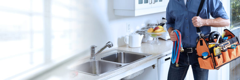 Plumber working beneath a kitchen sink