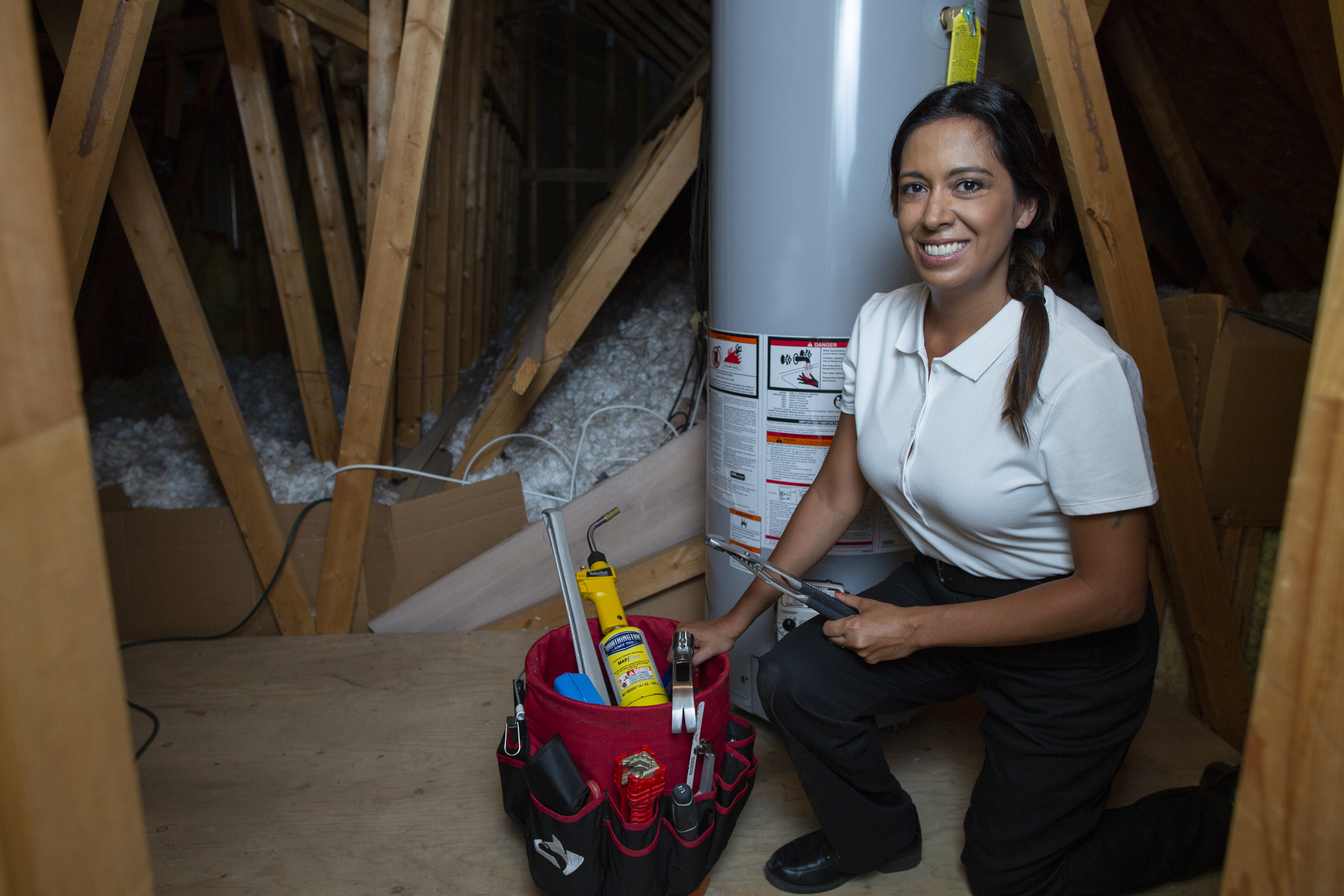 Our technician sitting in front of a recently finished water heater service in Crosby, Texas