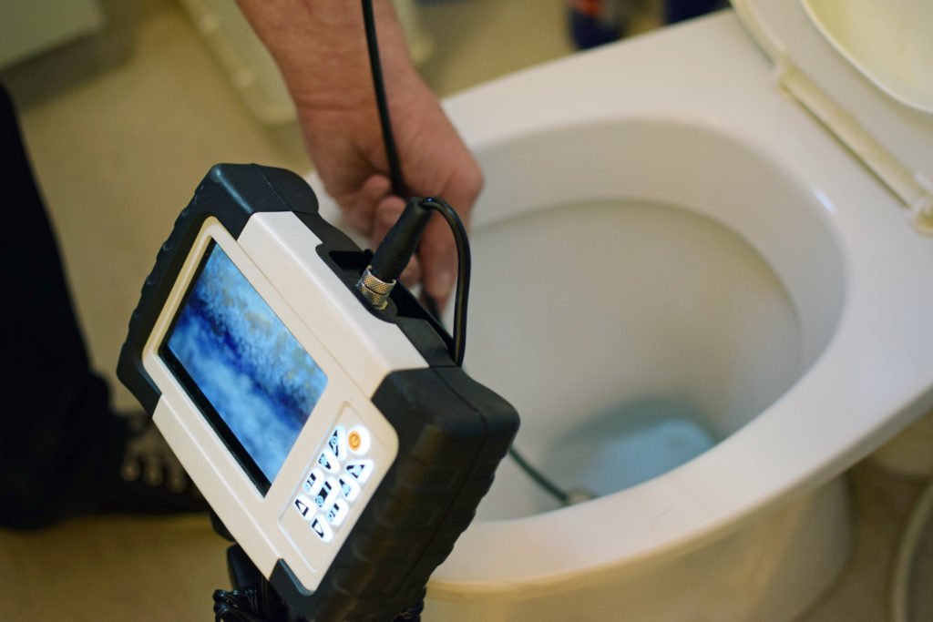 Plumber performing a camera inspection on a clogged sewer line