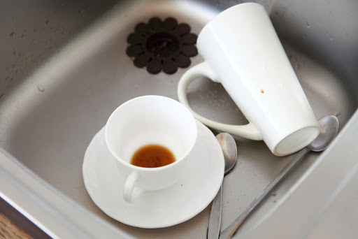 Two coffee cups in a sink.